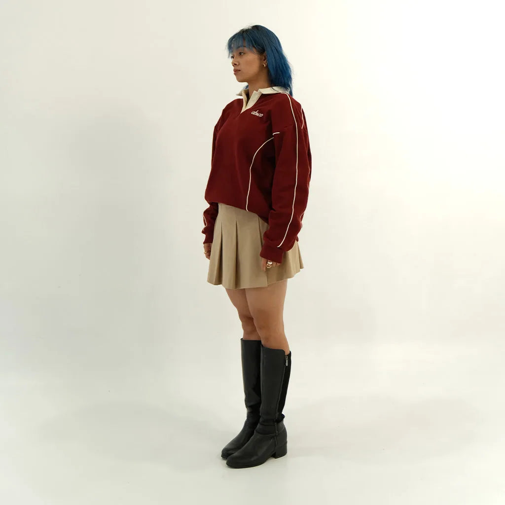 Female model in pomegranate red After Hours polo, side
