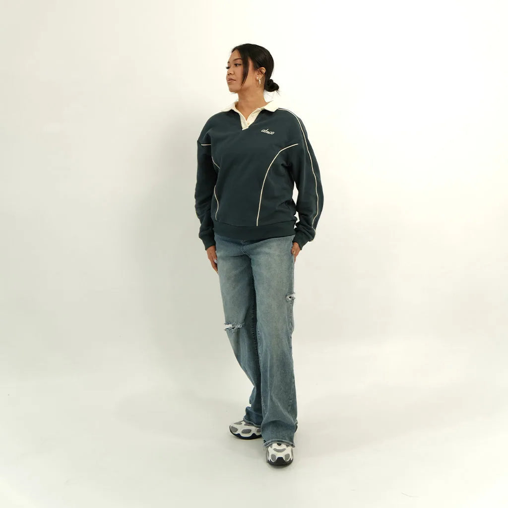 Female model styling the peacock teal After Hours polo