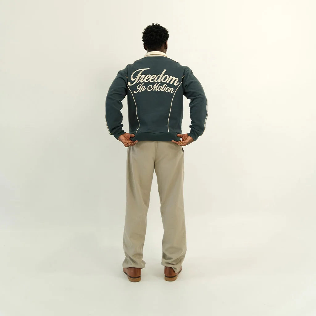 Peacock teal polo back, 'Freedom In Motion' embroidery, on model
