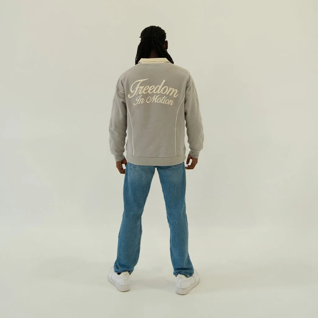 Slate grey polo back, 'Freedom In Motion' embroidery, on model