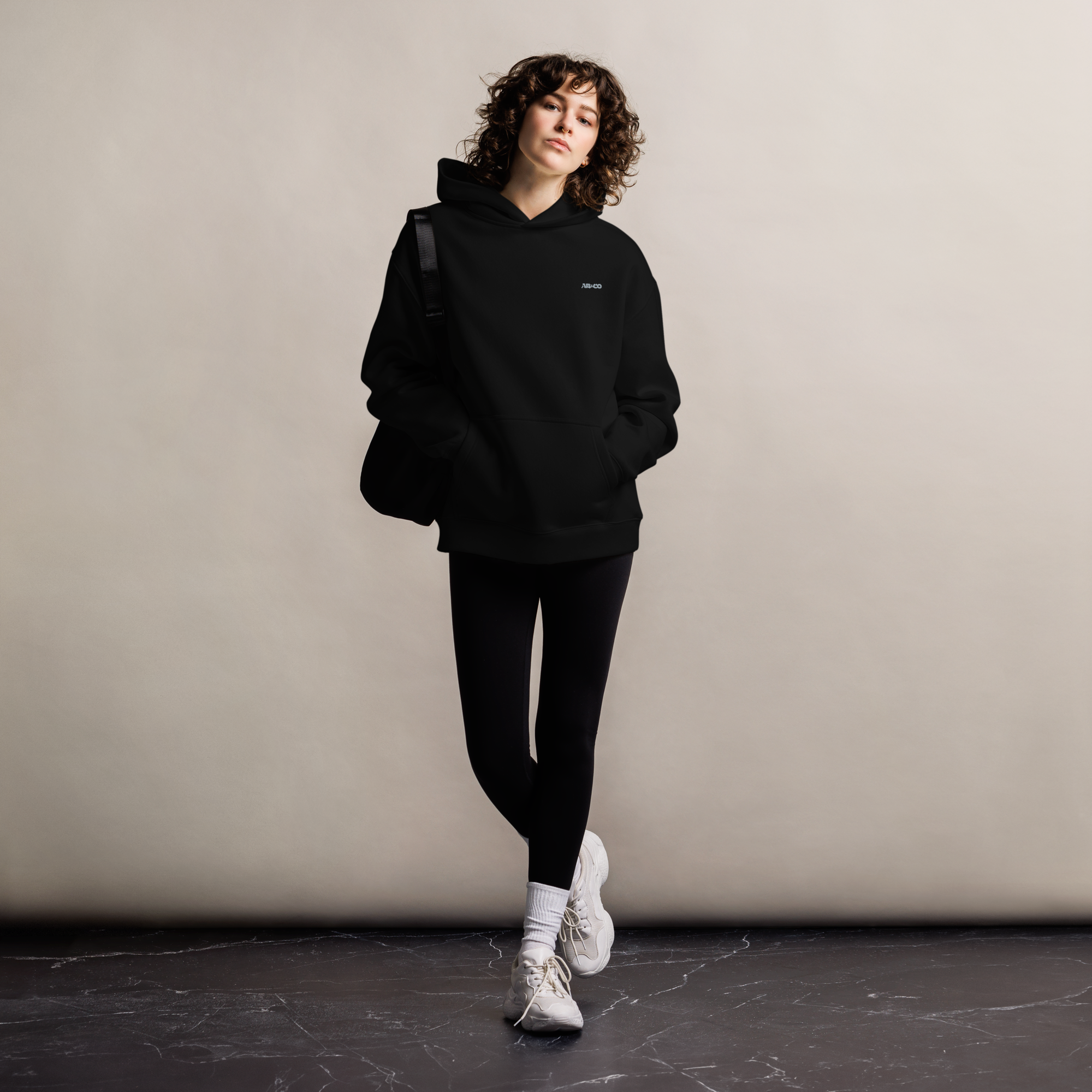 Heavyweight oversized hoodie in Black with dropped shoulders, double-layer hood, and ribbed cuffs, designed for streetwear and everyday comfort.