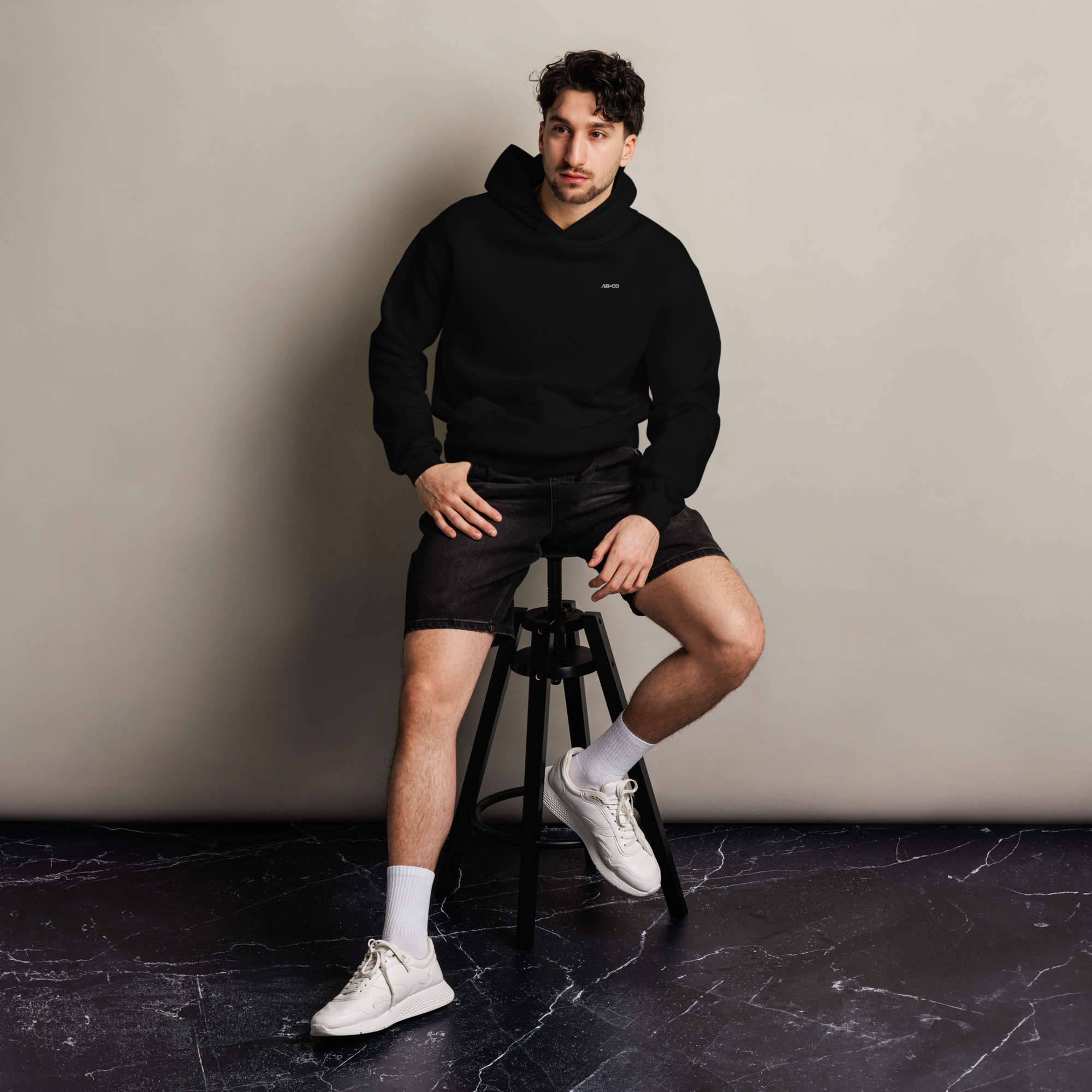Heavyweight oversized hoodie in Black with dropped shoulders, double-layer hood, and ribbed cuffs, designed for streetwear and everyday comfort.