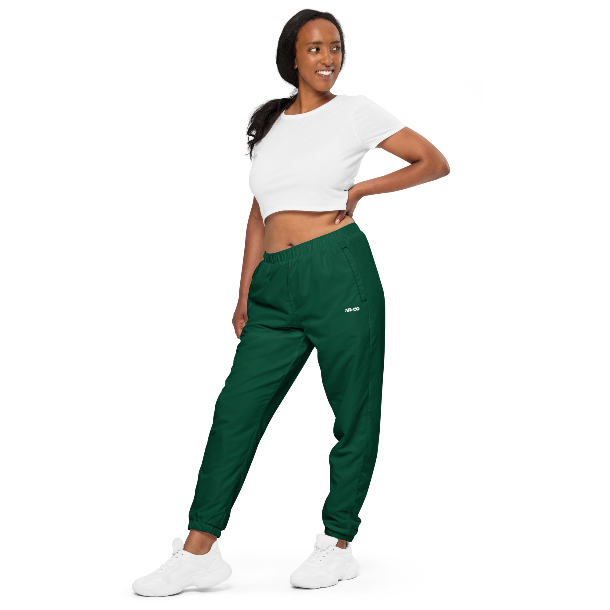 Unisex track pants in Green with elastic waistband, tapered leg, and side pockets. Designed for casual streetwear and comfort.