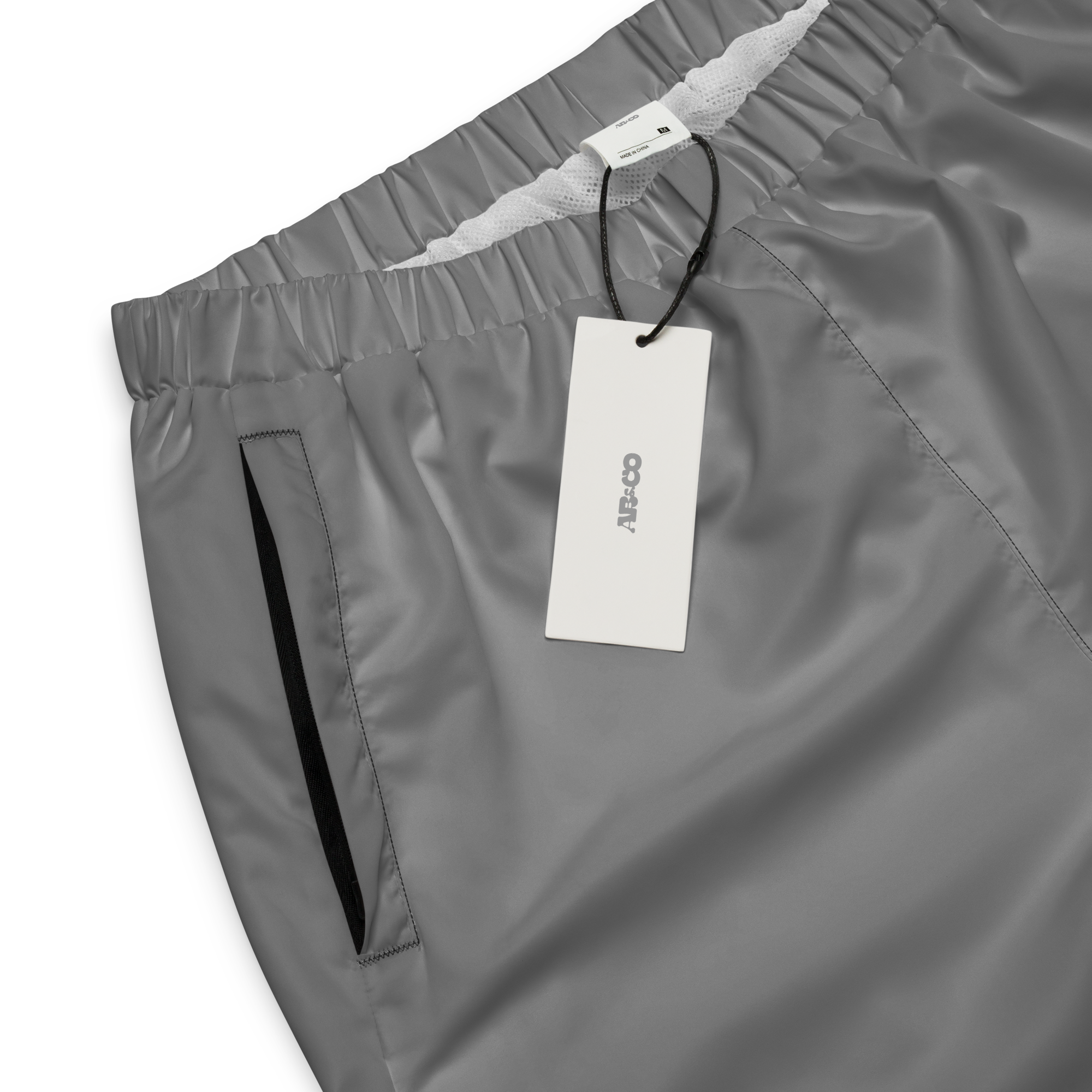 Unisex track pants in Grey with elastic waistband, tapered leg, and side pockets. Comfortable fit for streetwear and casual wear.